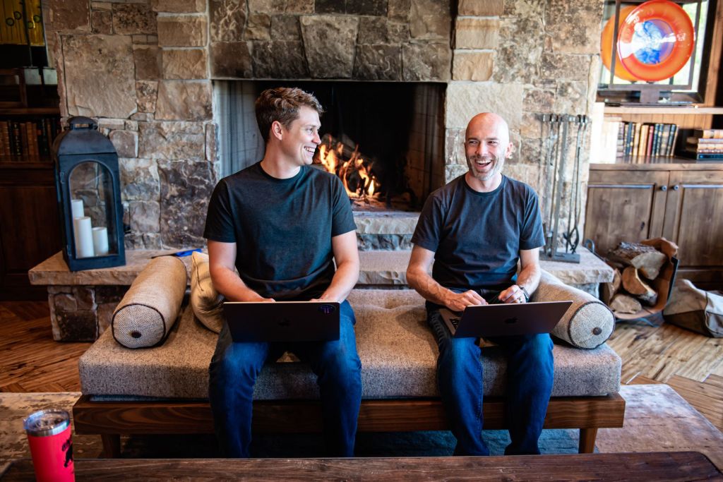Thatch founders sitting on couch in front of fireplace