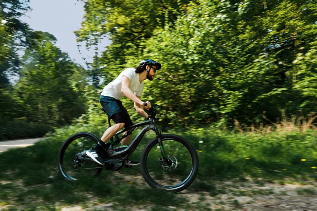 man rides black e-bike in nature