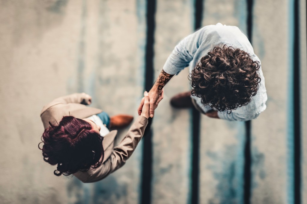 Overhead shot of manager shaking hand with job applicant.