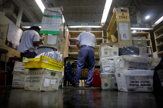 A USPS letter carrier sorts mail at his station inside the Roxbury Post Office in Nubian Square