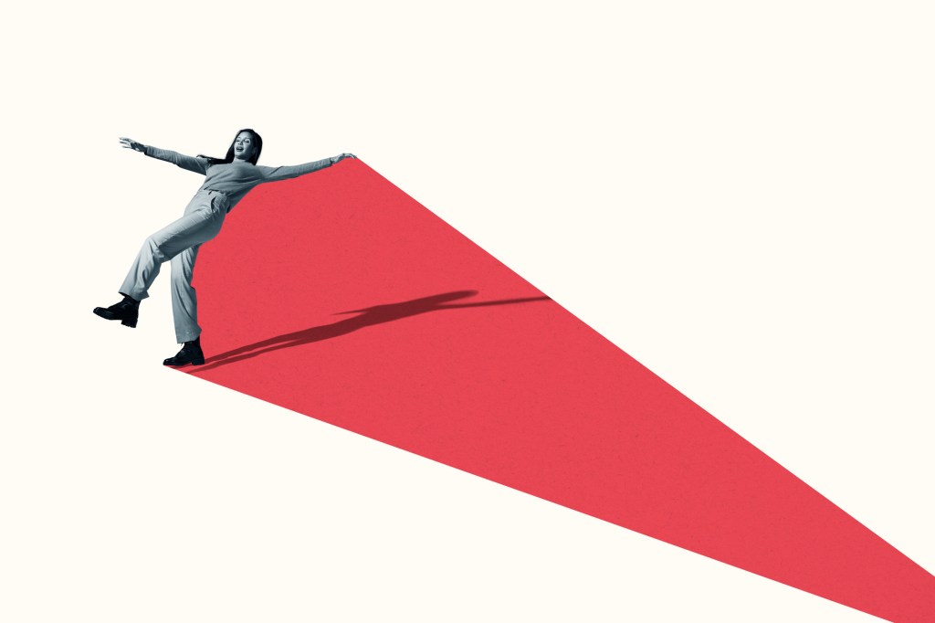 Full length of young woman avoiding to fall on vibrant red shape against white background