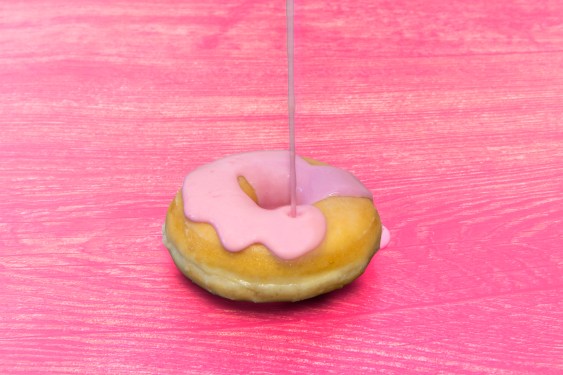 donut with pink toppings on a pink table