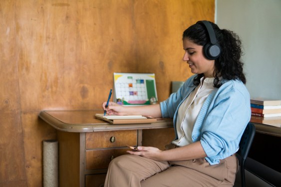 Therapist on a call writing in a notebook, used in a post about Intellect and IHH Healthcare
