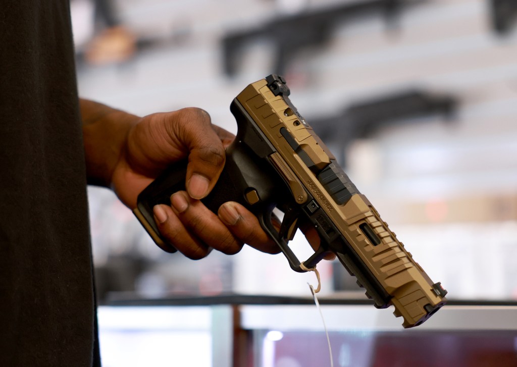 customer in gun shop holding a hand gun