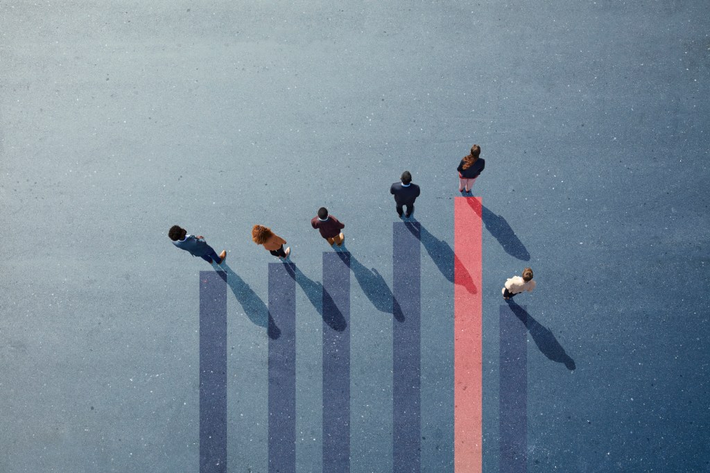 Group of employees photographed from above standing on graph.