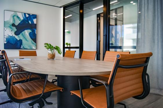 An empty board room with a round table and chairs