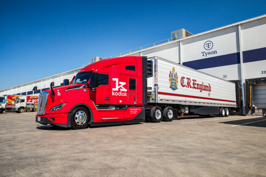 Kodiak Robotics truck with CR England trailer backed up to Tyson Foods warehouse loading bay
