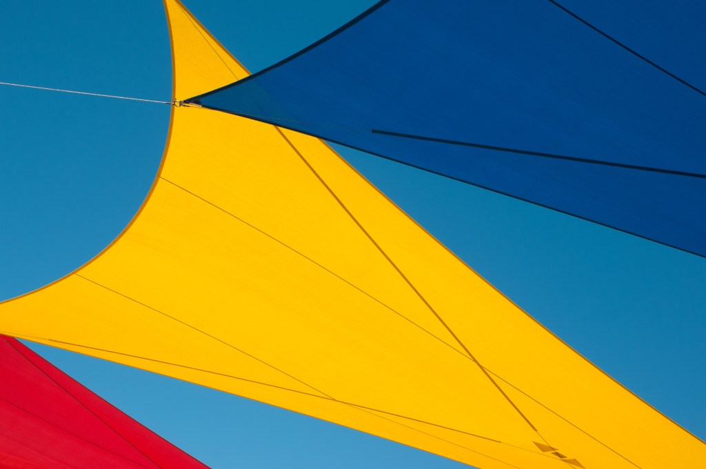 Brightly colored sails against a clear blue sky.