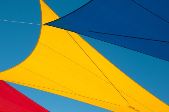 Brightly colored sails against a clear blue sky.