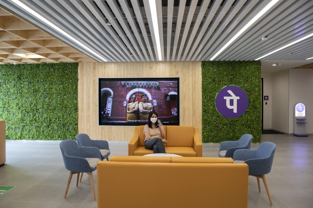 India's central bank abandons UPI rival project. Woman sitting in a lobby.