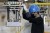 A worker wearing a blue hard hat moves a stack of batteries installing onto a battery pack for a kei electric vehicle (EV) on the production line