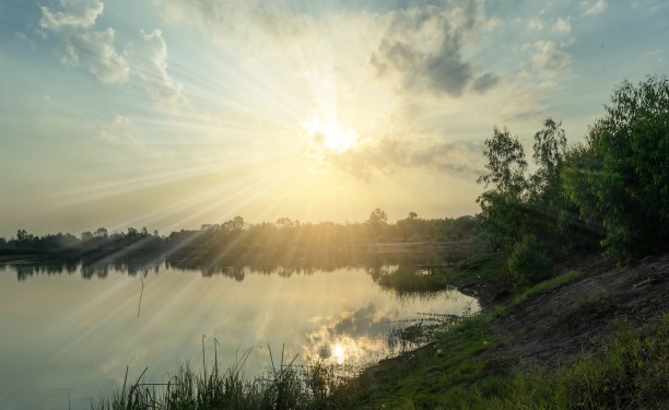 Bright sunshine through clouds over water.