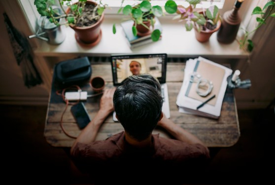 a photo from above looking at a person stood up at a desk on a video call