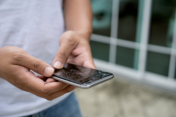 Man holding a broken smart phone in his hand