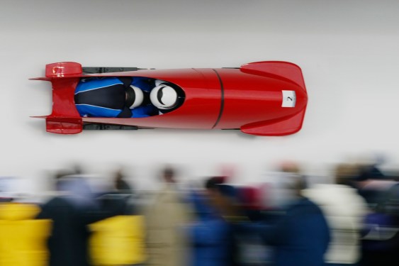 Two-man bobsled racing down track.