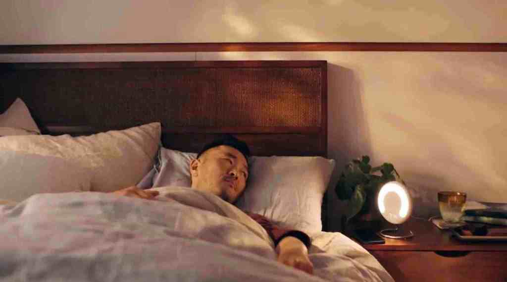 man in bed staring at Amazon Halo