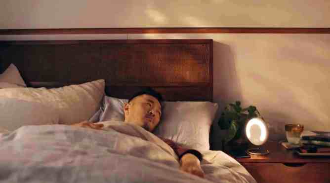 man in bed staring at Amazon Halo