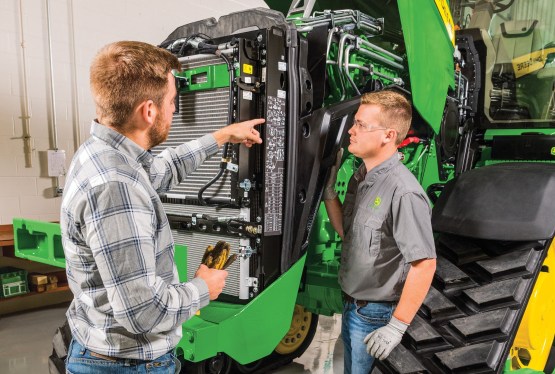 two men looking over a tractor