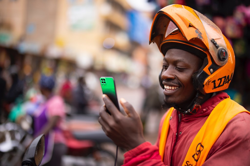 M-KOPA delivery driver looking at app while stopped