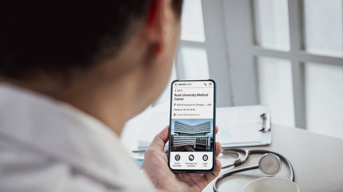 Carrum Health employer healthcare; man looking at smartphone app
