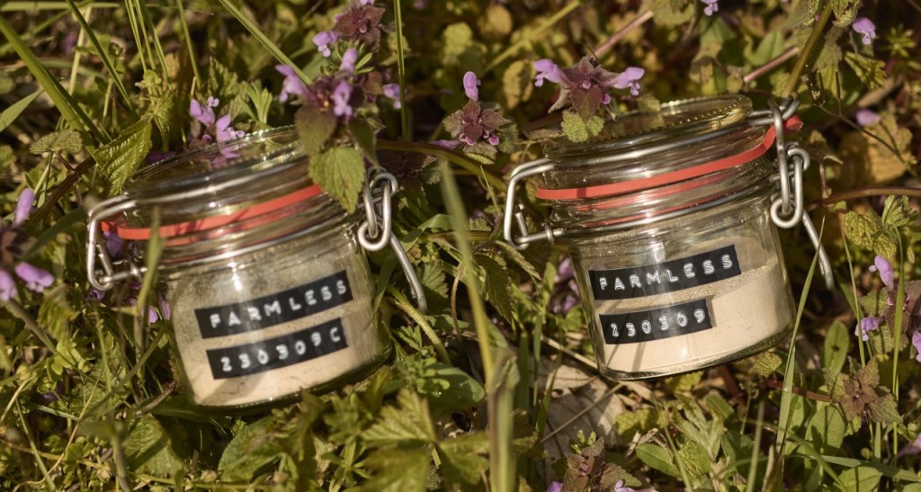 Jars of Farmless alternative proteins laying in green foliage