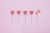 Five lollipop hearts on a pink floor, but the last one is smashed to pieces.