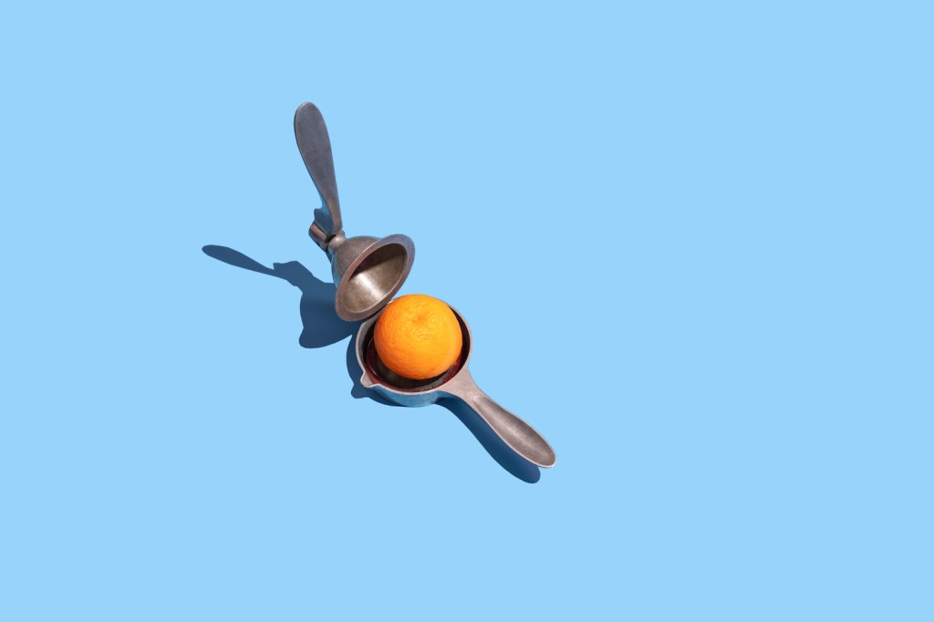 Lemon squeezer and blood orange on the blue background