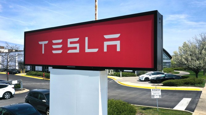 SCHAUMBURG, ILLINOIS - APRIL 19: A sign marks the location of a Tesla dealership on April 19, 2023 in Schaumburg, Illinois. Tesla announced price cuts for its Model 3 and Model Y electric vehicles in front of their 1st quarter earnings report due out today. (Photo by Scott Olson/Getty Images)