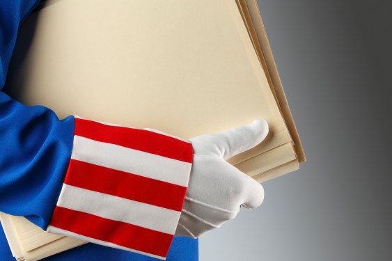 Uncle Sam holding a stack of file folders that may or may not contain private information on you, yes you.