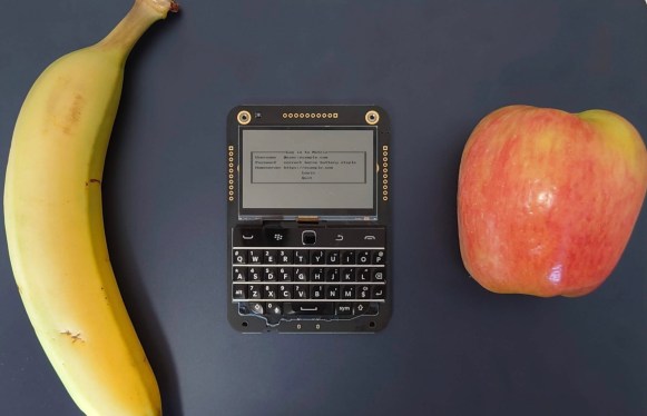 a banana, a handheld electronic device and an apple side by side