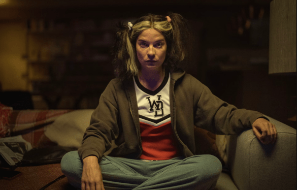 Woman sitting cross-legged on a couch; scene from Black Mirror