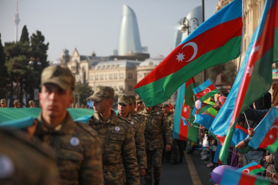 Azeri service members carry a giant flag during a procession marking the anniversary of the end of the 2020 military conflict over Nagorno-Karabakh breakaway region on November 8, 2021 in Baku, Azerbaijan.
