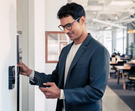 Man standing at door with security code panel