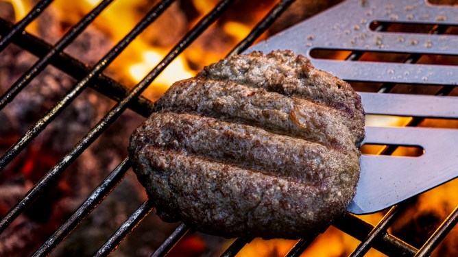 Omeat cultivated meat patty on a grill