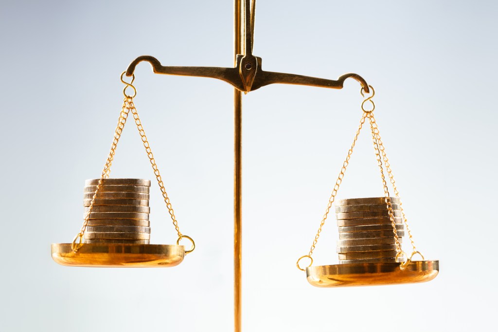 image of a scale with coins on both sides that is almost balanced.