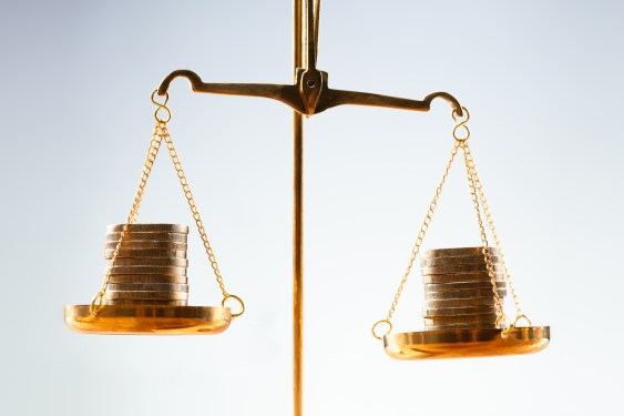 image of a scale with coins on both sides that is almost balanced.