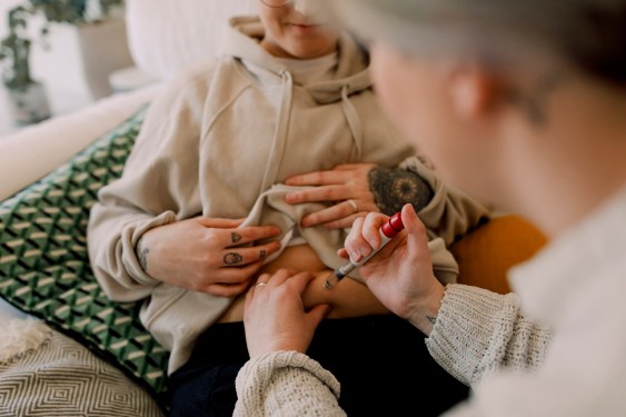 Lesbian couple doing IVF test with syringe at home