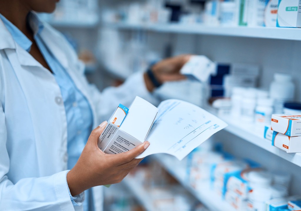 Pharmacist holding prescriptions