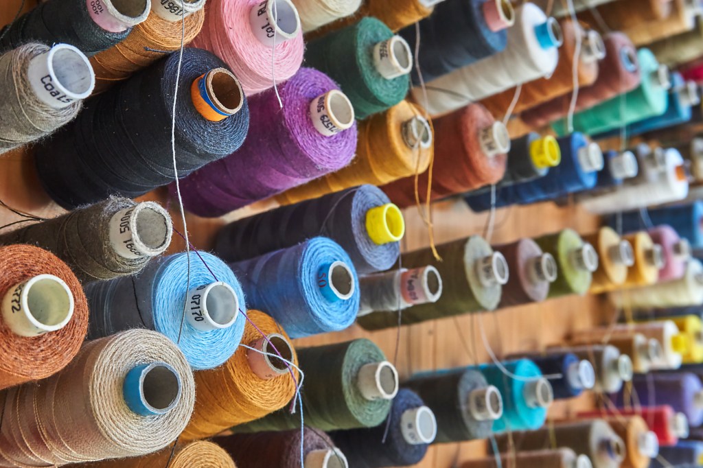 a lot of colorful bobbins on a wall