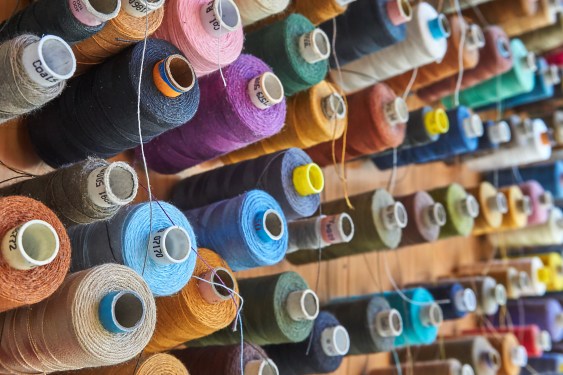 a lot of colorful bobbins on a wall