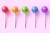 Set of five colorful sweet lollipops on pink pastel background. Round candies on stick. 3d rendering