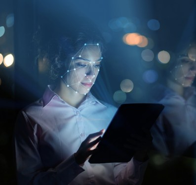 Portrait of a woman using facial recognition technology to access her tablet computer - online security concepts, used in post about Bureau