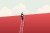 Business man slowly climbing a ladder and able to see over the top of the wall it's leaning against.