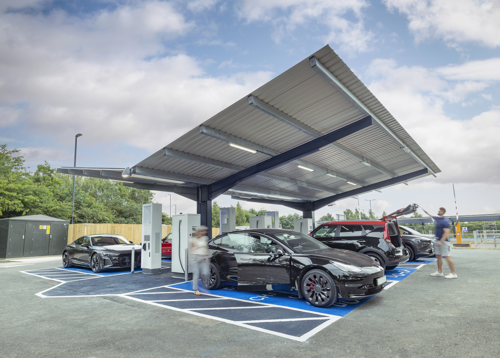 People charging their electric vehicles at a charging station