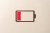 Paper Cut Craft Battery Only Has One Red Cell Left on Beige Background Directly Above View.
