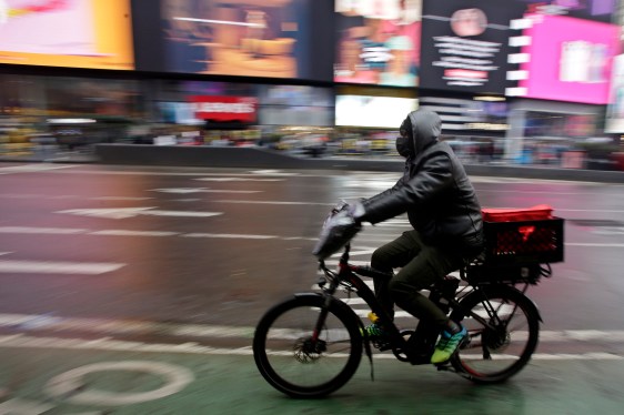 A man rides an e-bike through Times Square