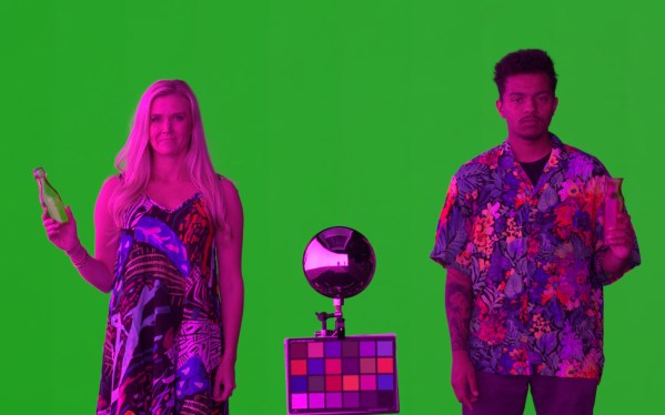 Actors lit in magenta against a green screen.