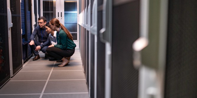 Team of engineers in a server room trying to diagnose a problem.