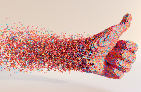 An abstract image of hundreds of small multi-coloured cubes moving through space to form a thumbs up symbol, against a plain light background. With copy space.