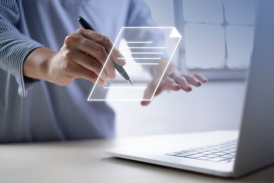 Woman applying electronic signature to a document coming out of a computer.
